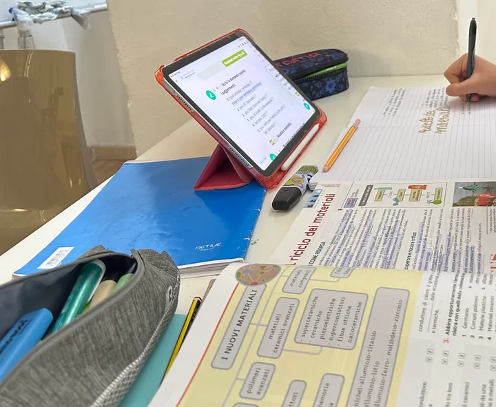 Un tablet, i quaderni e un astuccio sul banco durante lo studio pomeridiano